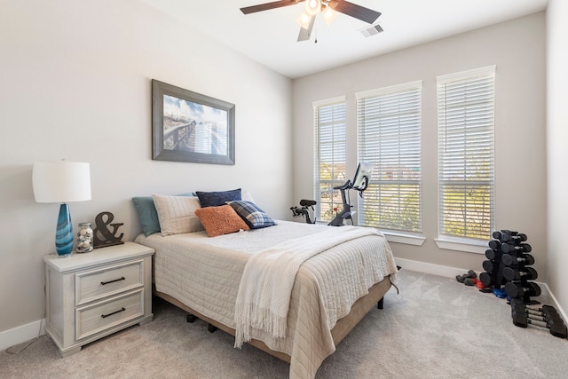 bedroom with light carpet, baseboards, visible vents, and a ceiling fan