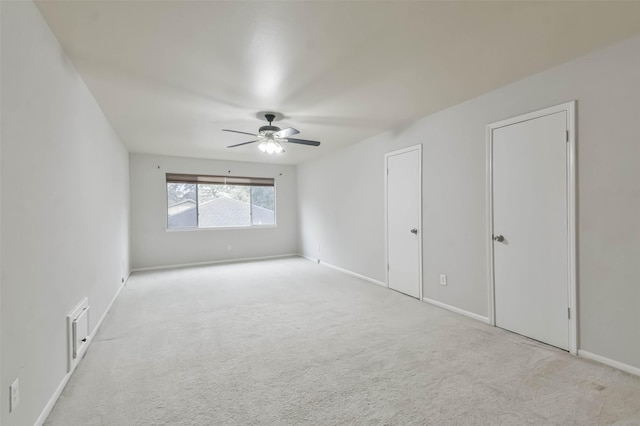 unfurnished room featuring baseboards, ceiling fan, and light colored carpet