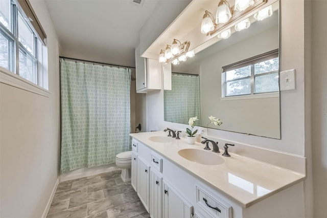 full bathroom with toilet, plenty of natural light, and a sink