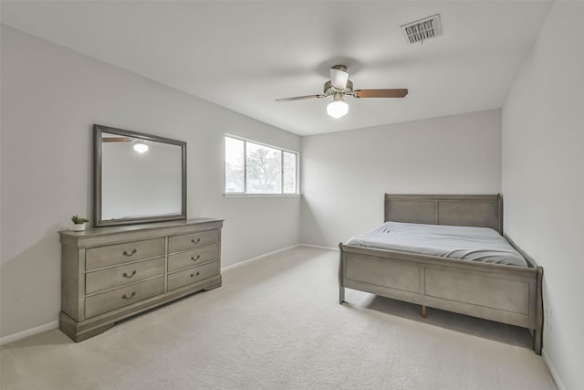 bedroom with light carpet, a ceiling fan, visible vents, and baseboards