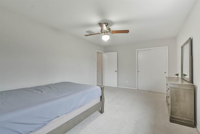 bedroom featuring light carpet, ceiling fan, a closet, and baseboards