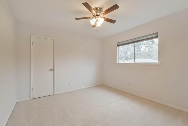 unfurnished room with ceiling fan, baseboards, and light colored carpet