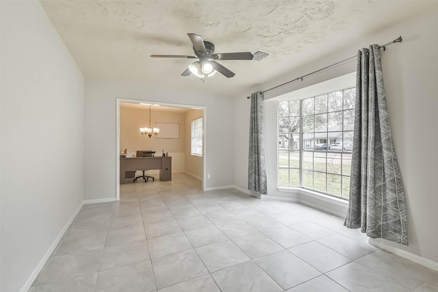 empty room with light tile patterned floors, ceiling fan with notable chandelier, visible vents, and baseboards