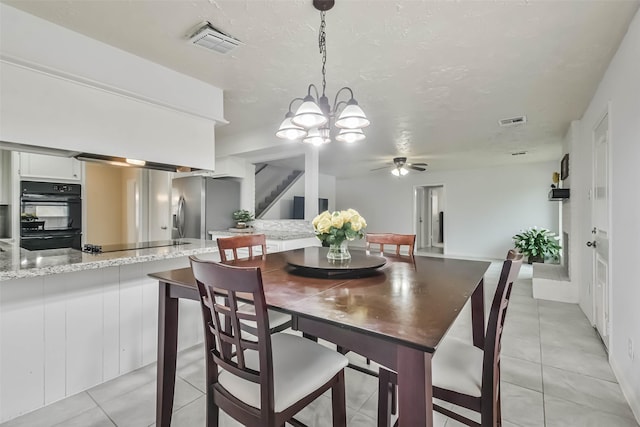 dining space featuring stairs, light tile patterned floors, a textured ceiling, and visible vents