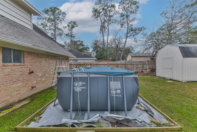 view of pool featuring a lawn, a fenced in pool, fence, a storage unit, and an outdoor structure