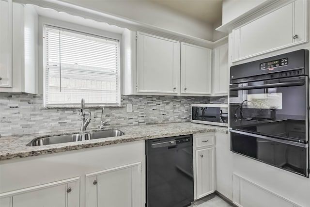 kitchen with black appliances, a sink, light stone countertops, and white cabinets