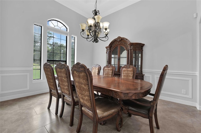 dining space with a healthy amount of sunlight, an inviting chandelier, a decorative wall, and a wainscoted wall