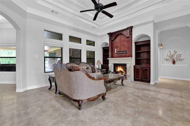 living room featuring a warm lit fireplace, visible vents, crown molding, and baseboards