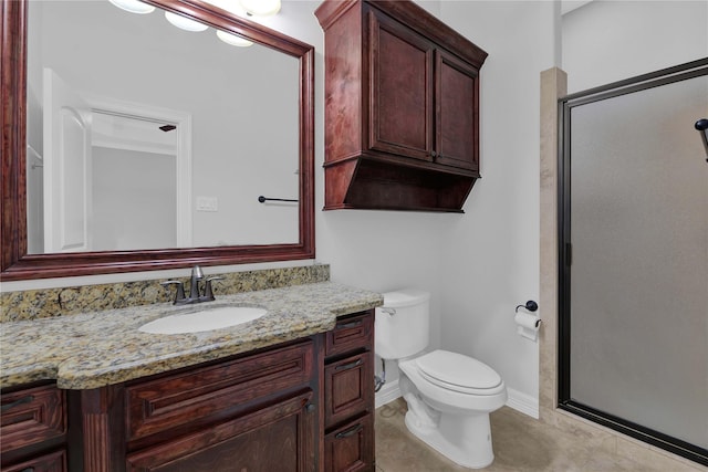 bathroom featuring toilet, vanity, a shower stall, baseboards, and tile patterned floors