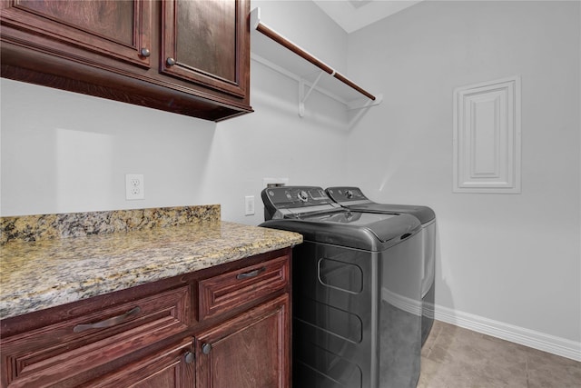 washroom featuring baseboards, cabinet space, washing machine and clothes dryer, and light tile patterned floors