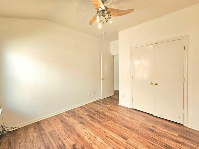 unfurnished bedroom featuring a closet, wood finished floors, a ceiling fan, and baseboards