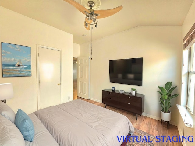 bedroom featuring lofted ceiling, a ceiling fan, baseboards, and wood finished floors