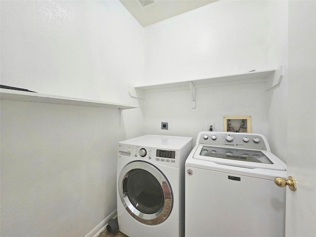 laundry area with laundry area, washing machine and dryer, visible vents, and baseboards