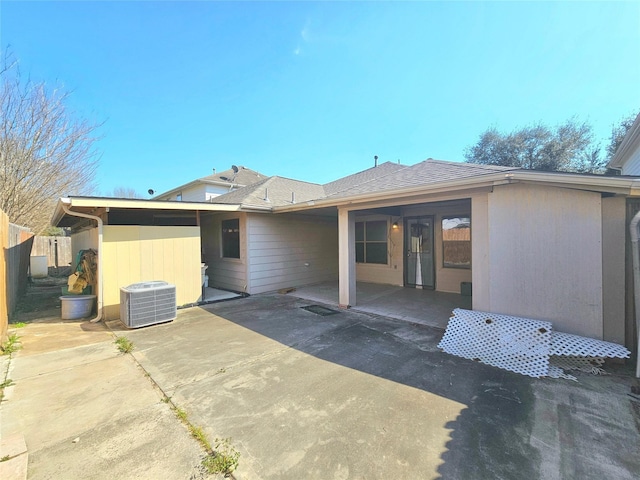 back of property with a shingled roof, cooling unit, a patio, and fence