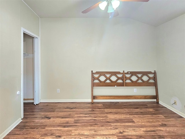 empty room with a ceiling fan, lofted ceiling, baseboards, and wood finished floors