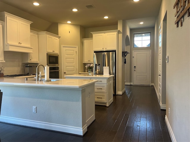 kitchen featuring premium range hood, a sink, stainless steel appliances, a peninsula, and white cabinets