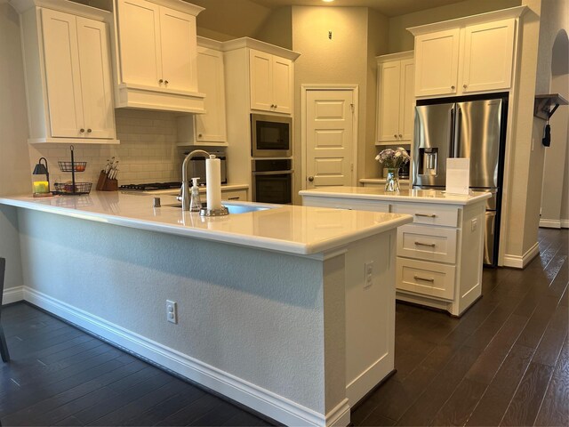 kitchen with a sink, stainless steel appliances, a peninsula, white cabinets, and custom exhaust hood