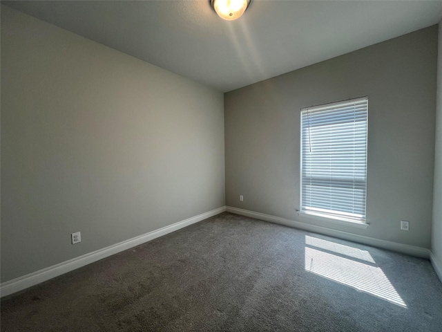 carpeted empty room featuring baseboards