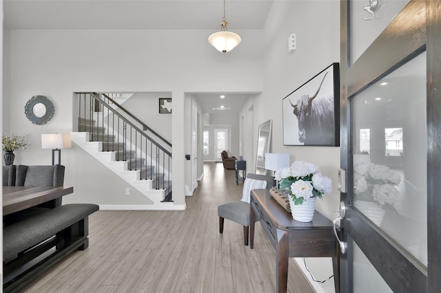 entrance foyer with baseboards, stairway, a high ceiling, and wood finished floors