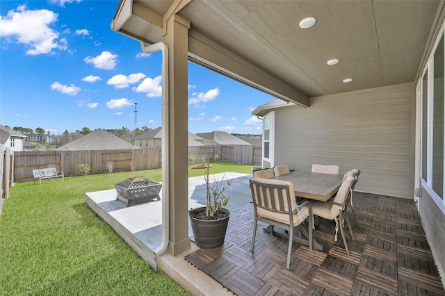 view of patio featuring an outdoor fire pit, a fenced backyard, a residential view, and outdoor dining space