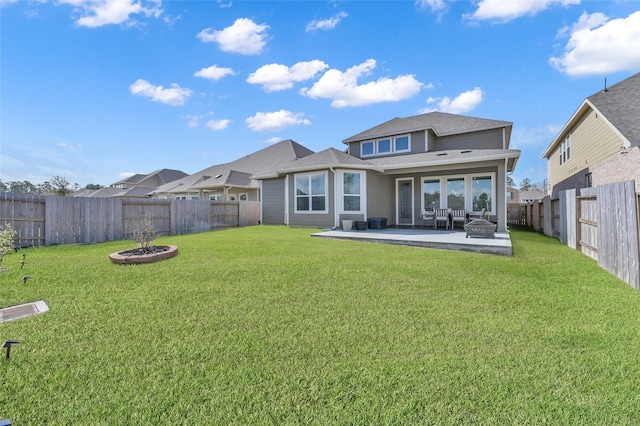 rear view of house with a patio area, a fenced backyard, and a lawn