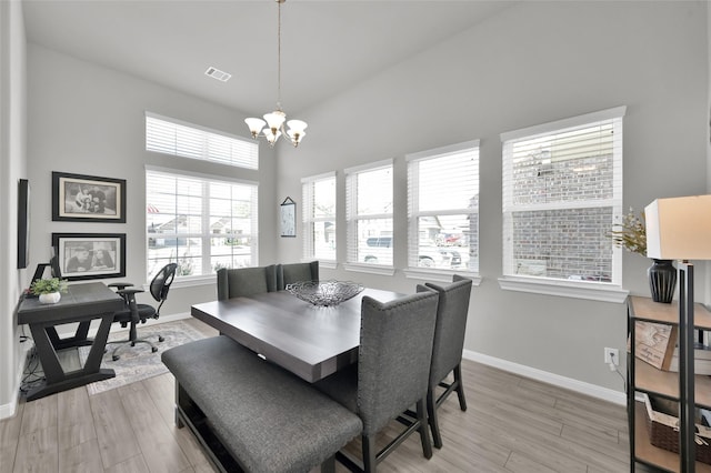 dining area with baseboards, light wood-style flooring, visible vents, and a notable chandelier