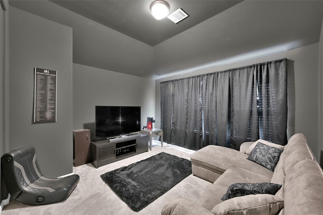 living room with lofted ceiling, carpet flooring, and visible vents