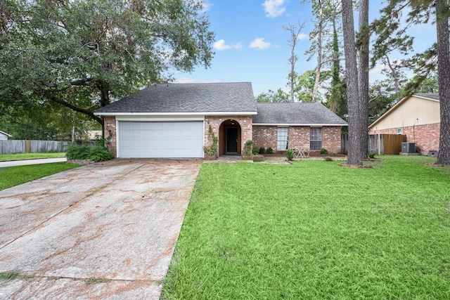 view of front of property featuring concrete driveway, an attached garage, a front yard, central AC, and fence