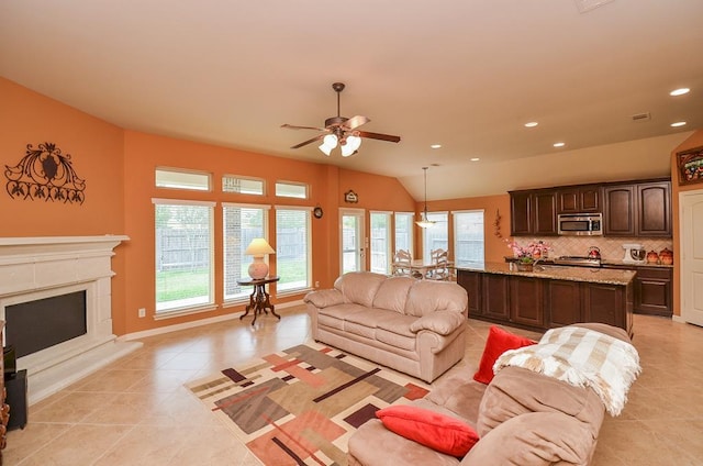 living area featuring light tile patterned floors, ceiling fan, a premium fireplace, and recessed lighting