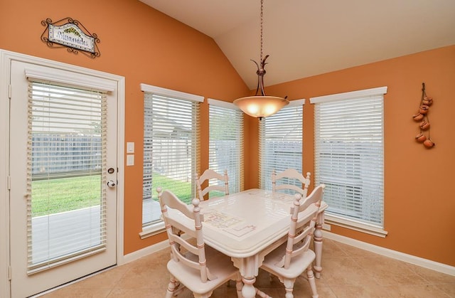 dining area featuring lofted ceiling, light tile patterned floors, and baseboards