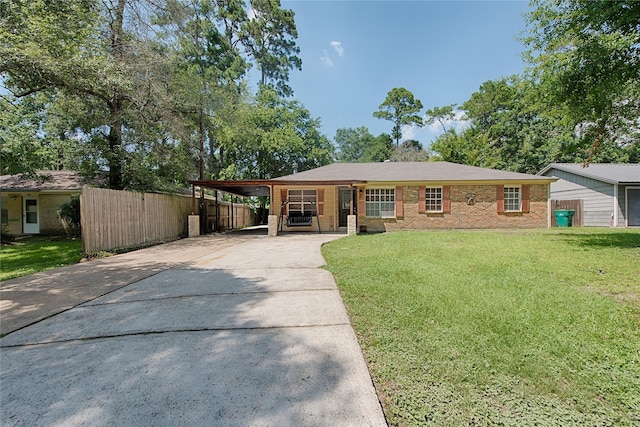 ranch-style home with brick siding, fence, driveway, a carport, and a front yard