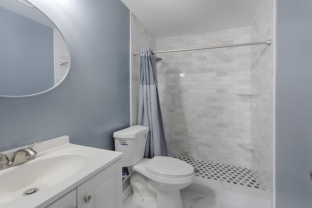 bathroom with marble finish floor, a tile shower, vanity, and toilet