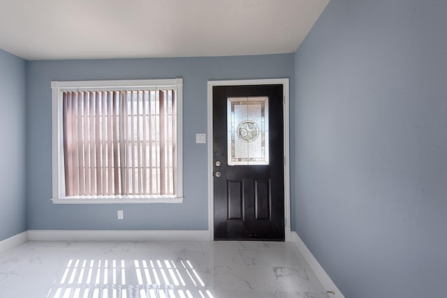 entrance foyer with marble finish floor and baseboards