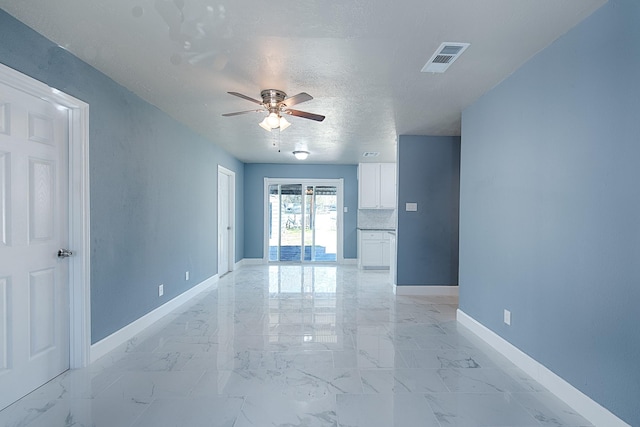 unfurnished room with marble finish floor, baseboards, visible vents, and a textured ceiling