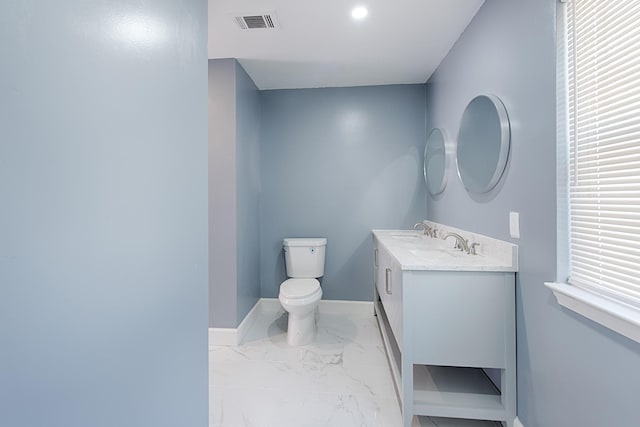 bathroom featuring marble finish floor, visible vents, toilet, vanity, and baseboards