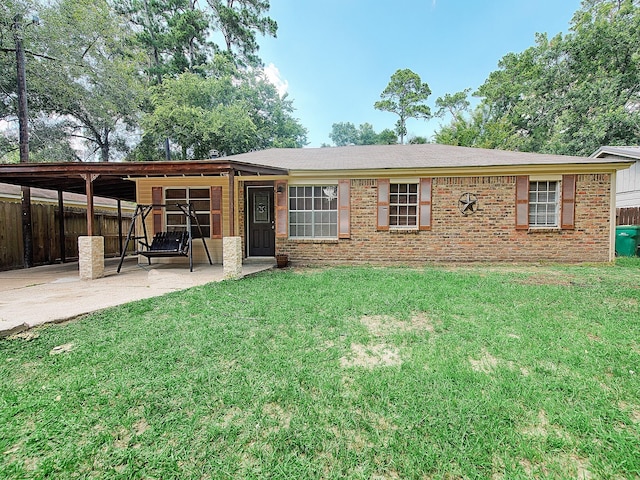 view of front of property with a patio area, brick siding, a front yard, and fence