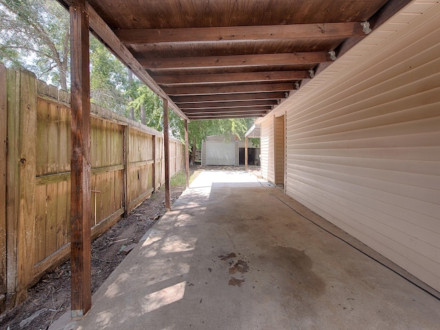 view of patio / terrace with a fenced backyard, a storage unit, and an outbuilding