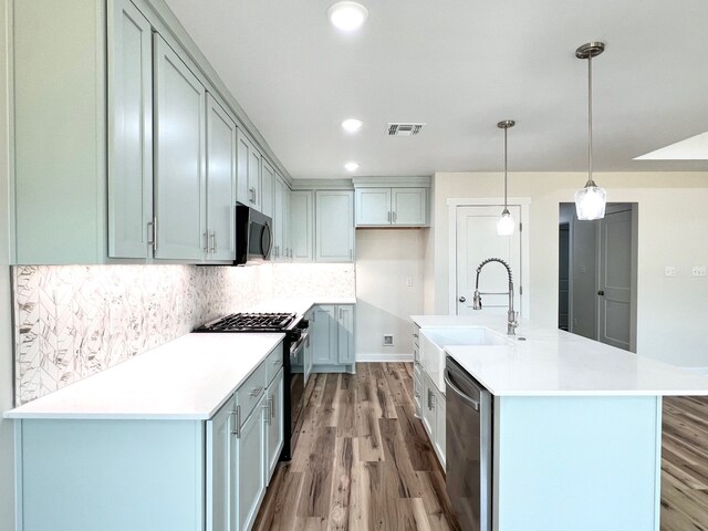 809 Flycatcher Dr, Palacios, TX 77465 - kitchen with stainless steel appliances, wood finished floors, visible vents, and a sink