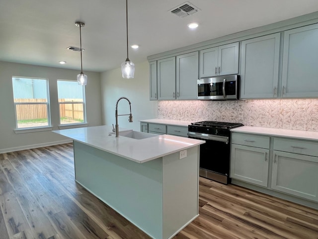 809 Flycatcher Dr, Palacios, TX 77465 - kitchen with stainless steel microwave, a sink, visible vents, black gas range, and backsplash