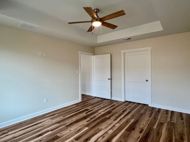 809 Flycatcher Dr, Palacios, TX 77465 - unfurnished bedroom featuring baseboards, dark wood-style flooring, ceiling fan, and visible vents