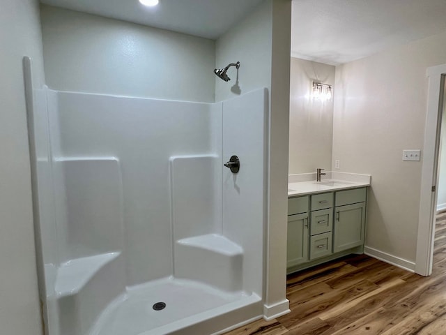 809 Flycatcher Dr, Palacios, TX 77465 - full bathroom featuring vanity, baseboards, a shower, and wood finished floors
