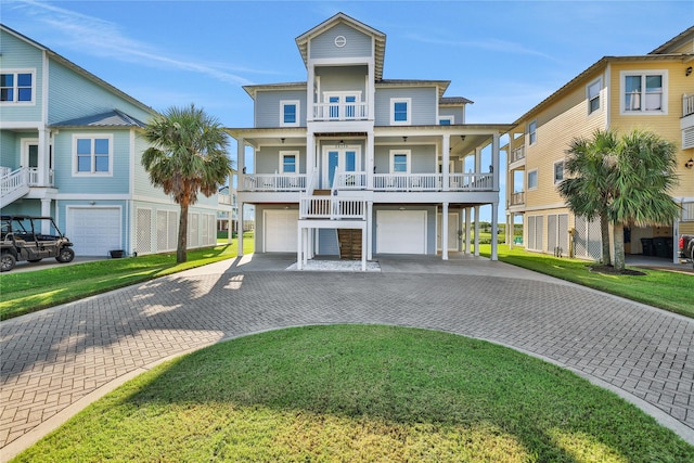 beach home with decorative driveway, french doors, a balcony, a garage, and a residential view