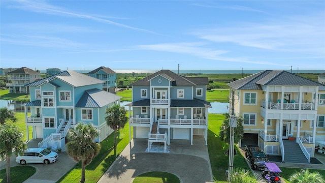 exterior space with stairs, driveway, a water view, and a residential view