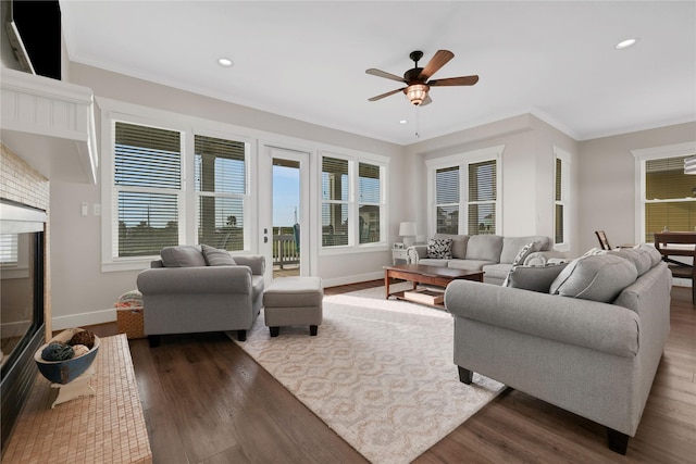 living room featuring ornamental molding, recessed lighting, dark wood-style flooring, and baseboards