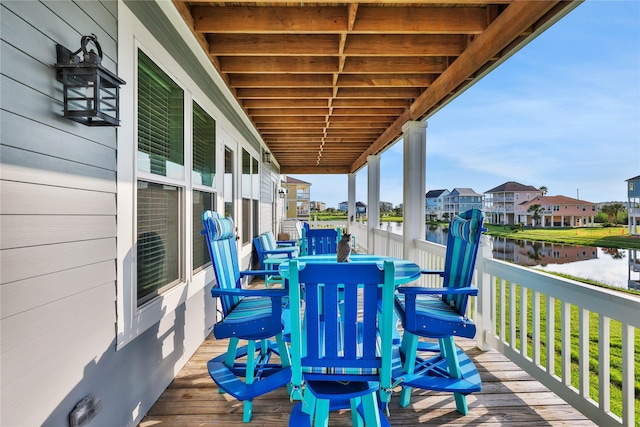 wooden deck with a residential view and a water view