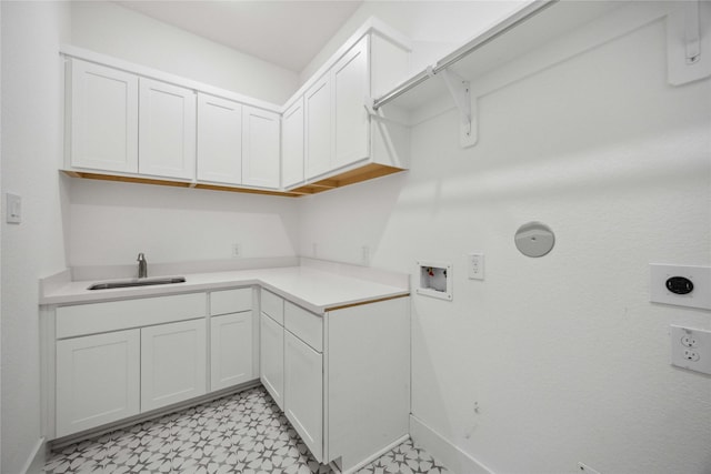 washroom with a sink, baseboards, hookup for a washing machine, cabinet space, and light floors