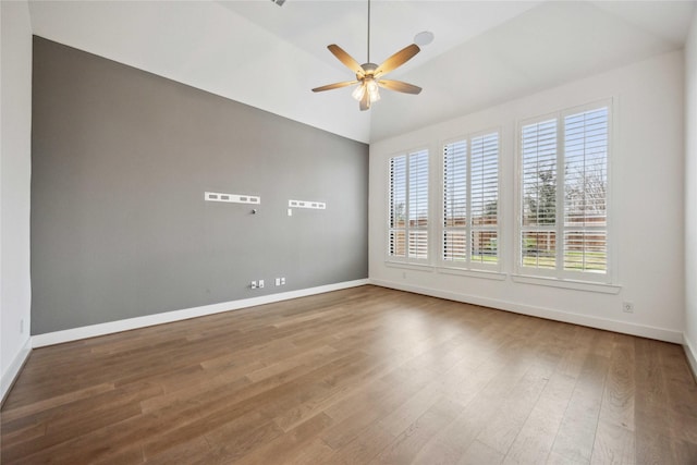 spare room featuring ceiling fan, baseboards, lofted ceiling, and wood finished floors