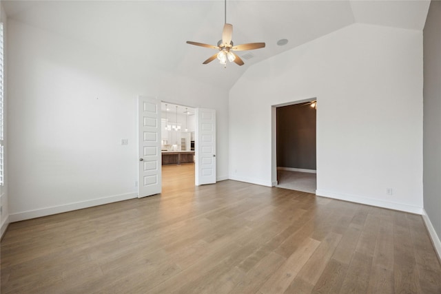 interior space with baseboards, vaulted ceiling, wood finished floors, and ceiling fan