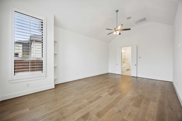 unfurnished room featuring wood finished floors, vaulted ceiling, visible vents, and ceiling fan
