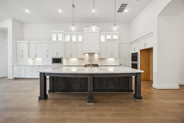 kitchen featuring decorative backsplash, appliances with stainless steel finishes, a sink, and visible vents